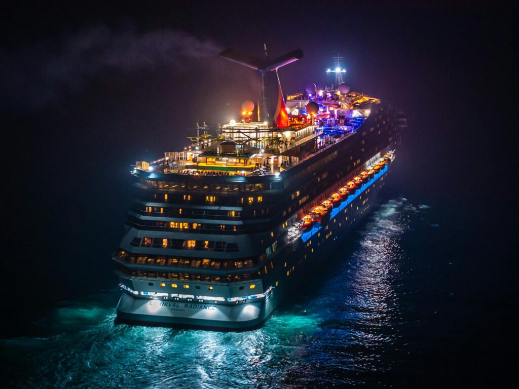 pexels photo 34748742 34748742 A vividly lit cruise ship sails through dark waters at night, creating a striking contrast.